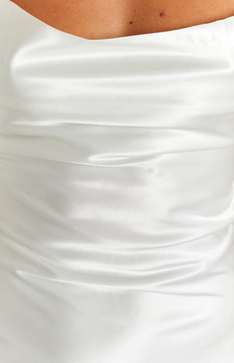 Close-up of the white satin fabric of the party dress, showing its sheen and horizontal ruching detail