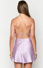 Rear view of a lilac satin party dress showing criss-cross spaghetti straps, a low open back, and tie detail