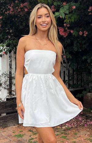 White strapless mini dress with side cutouts, elasticated waist, and a full, flowy skirt