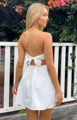 Beginning Boutique Cora White Tie Back Mini Dress white strapless mini dress with a large back tie and waist cutouts