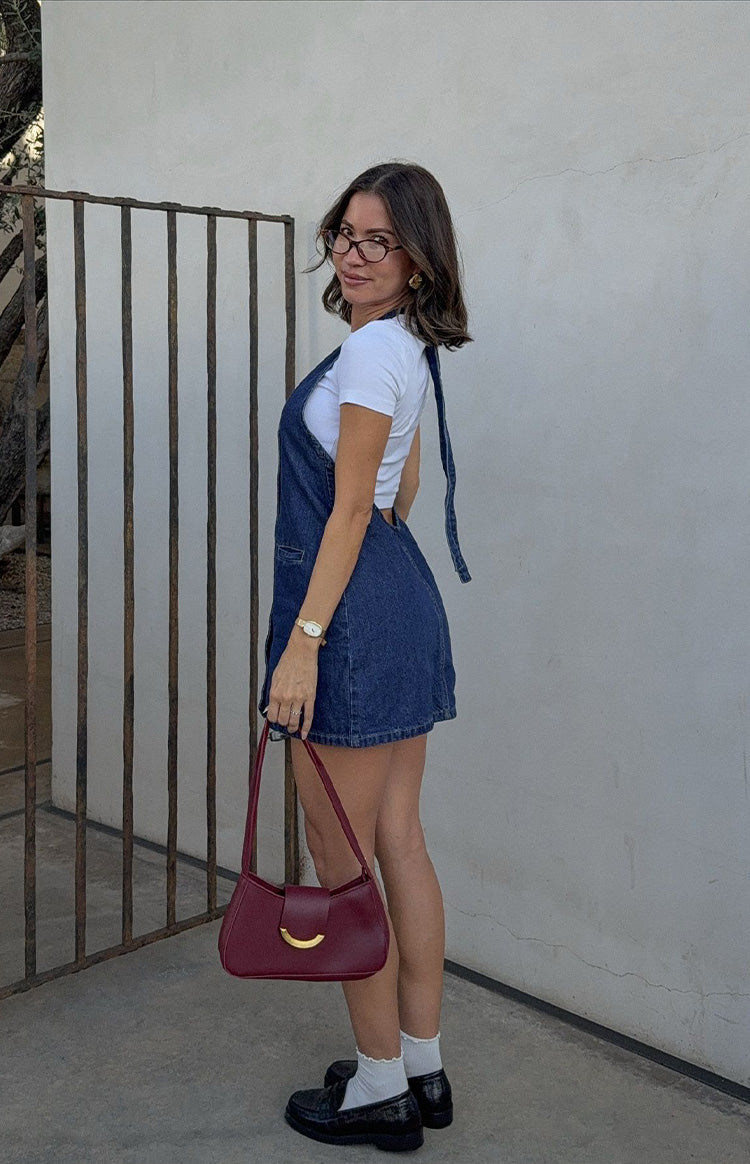 Rear view of a blue denim mini dress showing the halter neck ties and open back