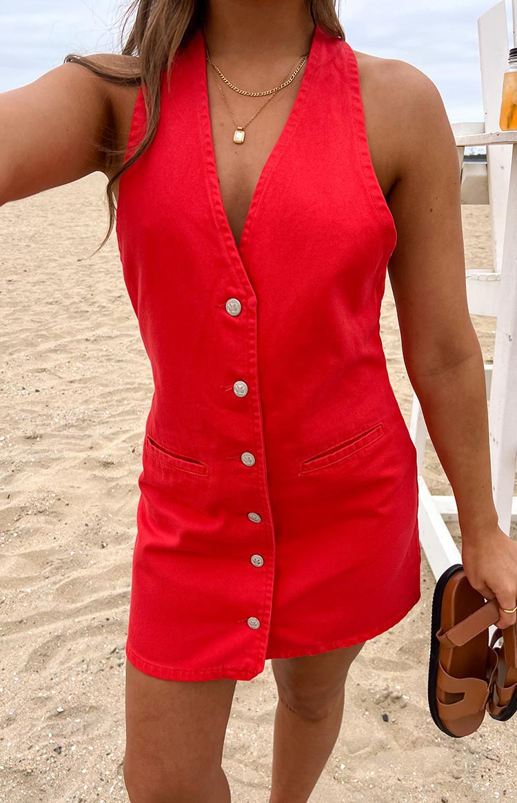 Red denim halter mini dress with a deep V-neck, silver button-front, and two small flap pockets