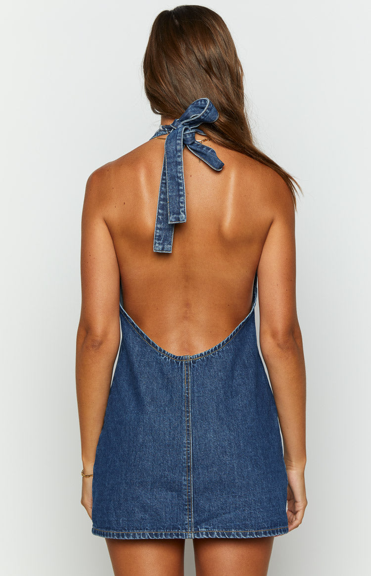 Rear view showing the denim halter neck tie and deep scoop back of a blue denim mini dress