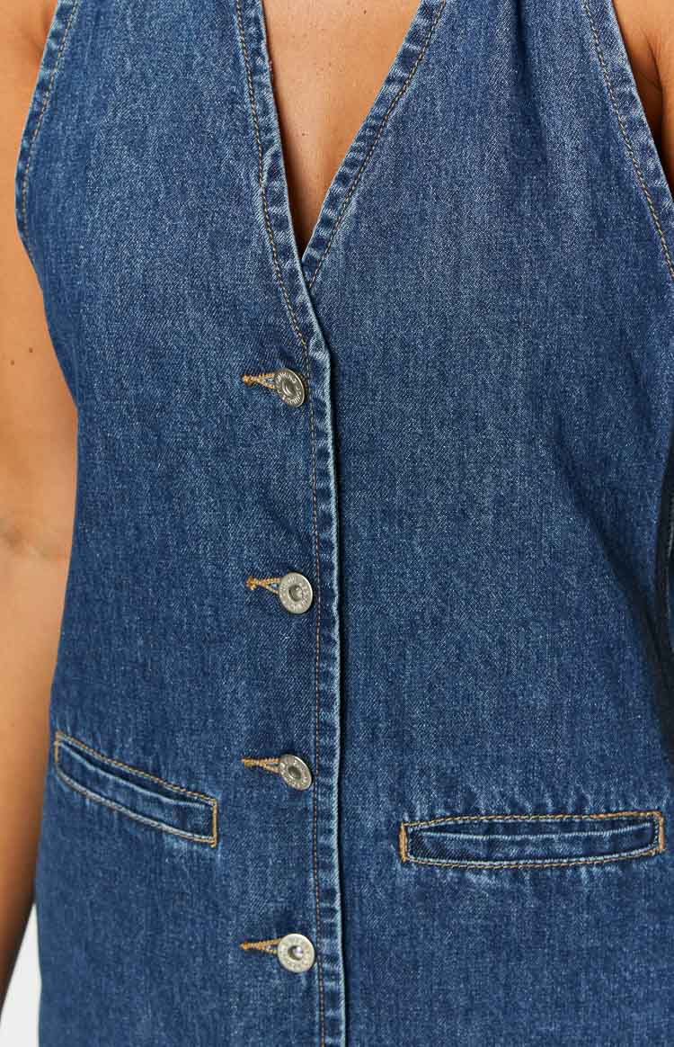 Dark wash denim halter neck mini dress with a full button-front closure and two front patch pockets
