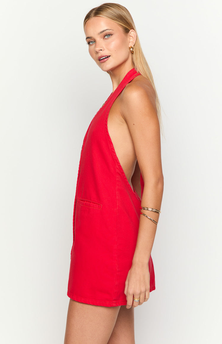 Side view of a red denim mini dress with deep side cutouts, a halter neckline, and a side pocket