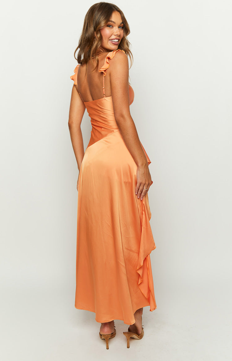 Orange satin maxi dress with ruffled shoulder straps, wrap V-neck, and a flowing asymmetrical high-low hem