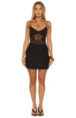 Front view of a black mini dress with a V-neckline, spaghetti straps, and a sheer lace midriff panel