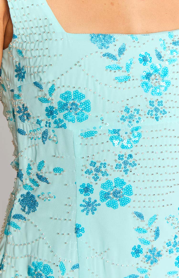 Close-up of the light blue mini dress showing the intricate floral pattern made from blue sequins and silver beads