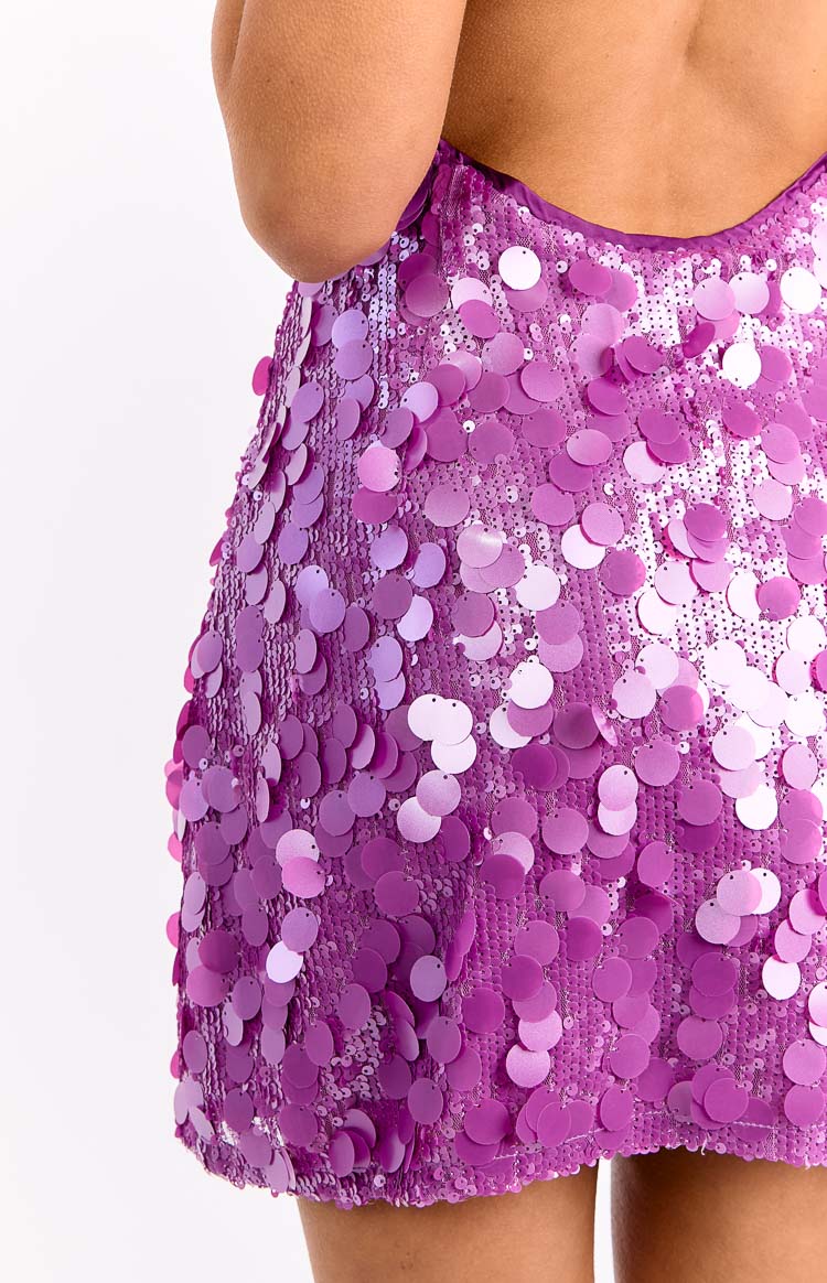 Close-up of the purple sequin mini dress, showing the texture of the round sequins and the low back