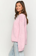 Light pink chunky knit sweater with a relaxed fit, V-neck, dropped shoulders, and wide cuffs