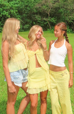 White ribbed knit halter neck top with a scoop neckline and cropped fit
