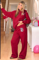 Burgundy track pants with an elasticated waistband and a leopard print 10 patch on the left thigh in a relaxed wide-leg fit