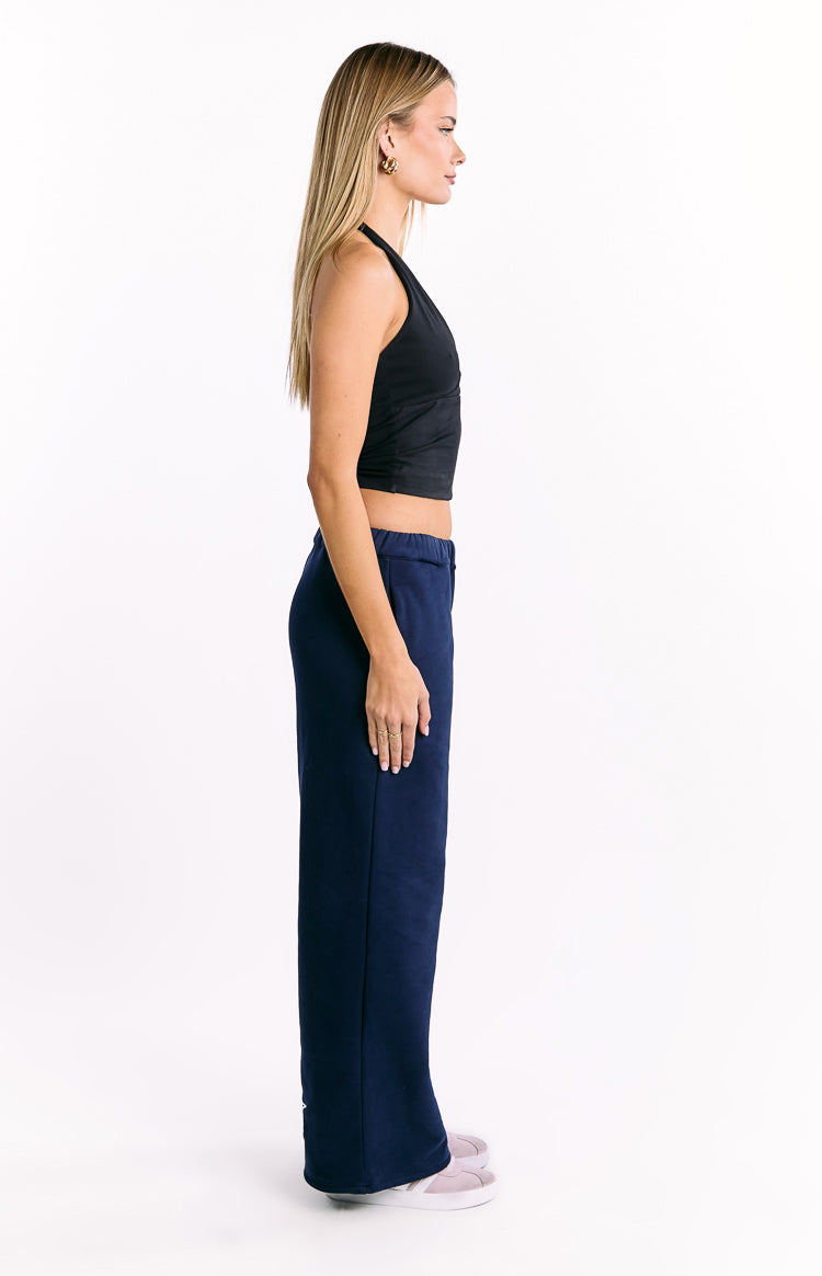 Side view of navy track pants with a relaxed wide-leg fit and elasticated high waist