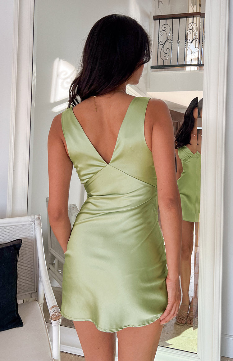 Rear view of a sage satin mini dress showing the deep V-neck back and smooth, flowing fabric