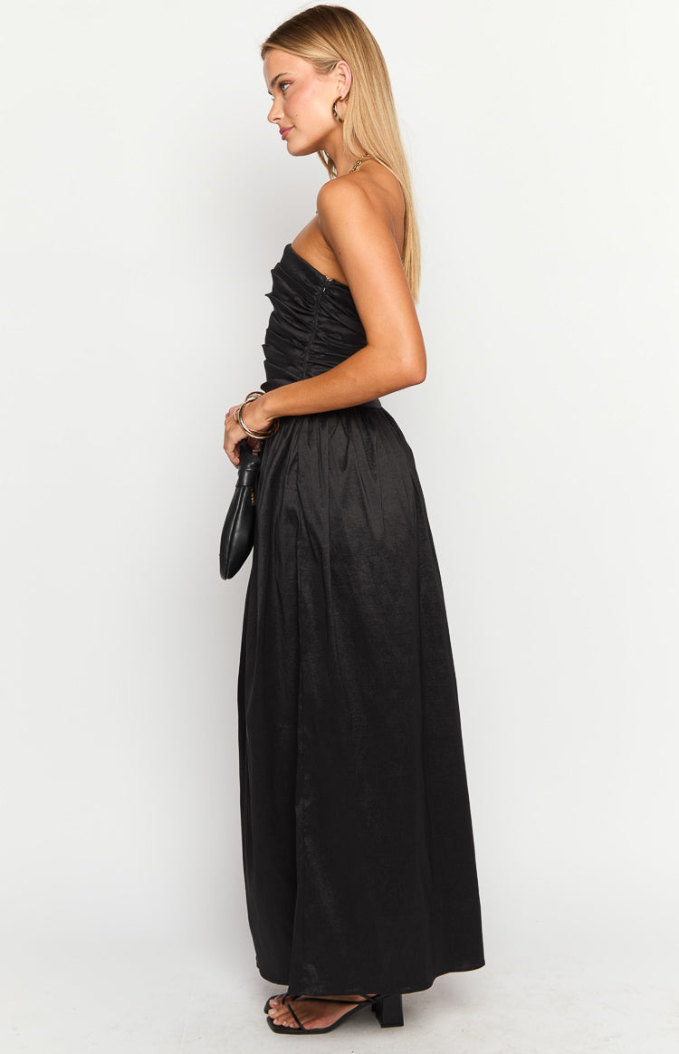Side view of a black textured strapless maxi dress with a ruched bodice and flowing skirt