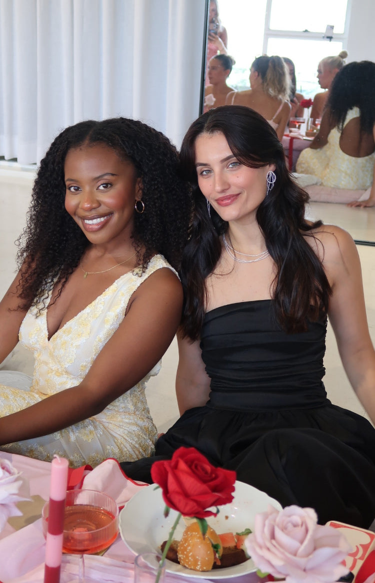 Close-up of the black strapless maxi dress showing the ruched bodice and full gathered skirt
