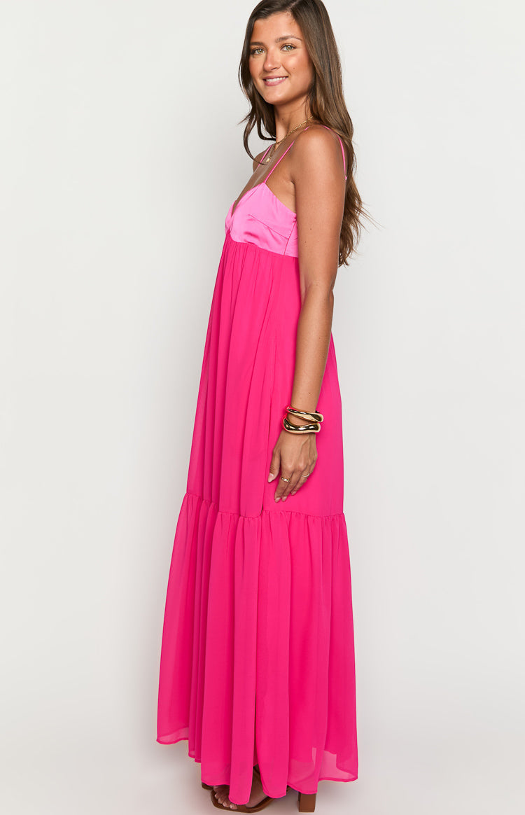 Side view of the hot pink maxi dress showing the satin bodice and flowy tiered skirt