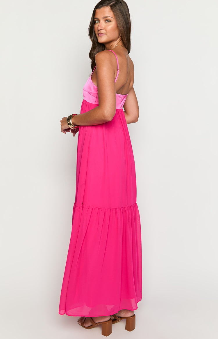 Side view of the hot pink maxi dress with a contrasting pink satin bodice and a tiered maxi skirt
