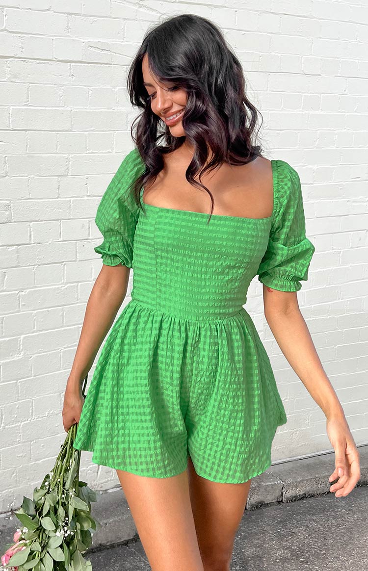 Side view of a green gingham playsuit with puffed short sleeves, square neckline, and shirred waist