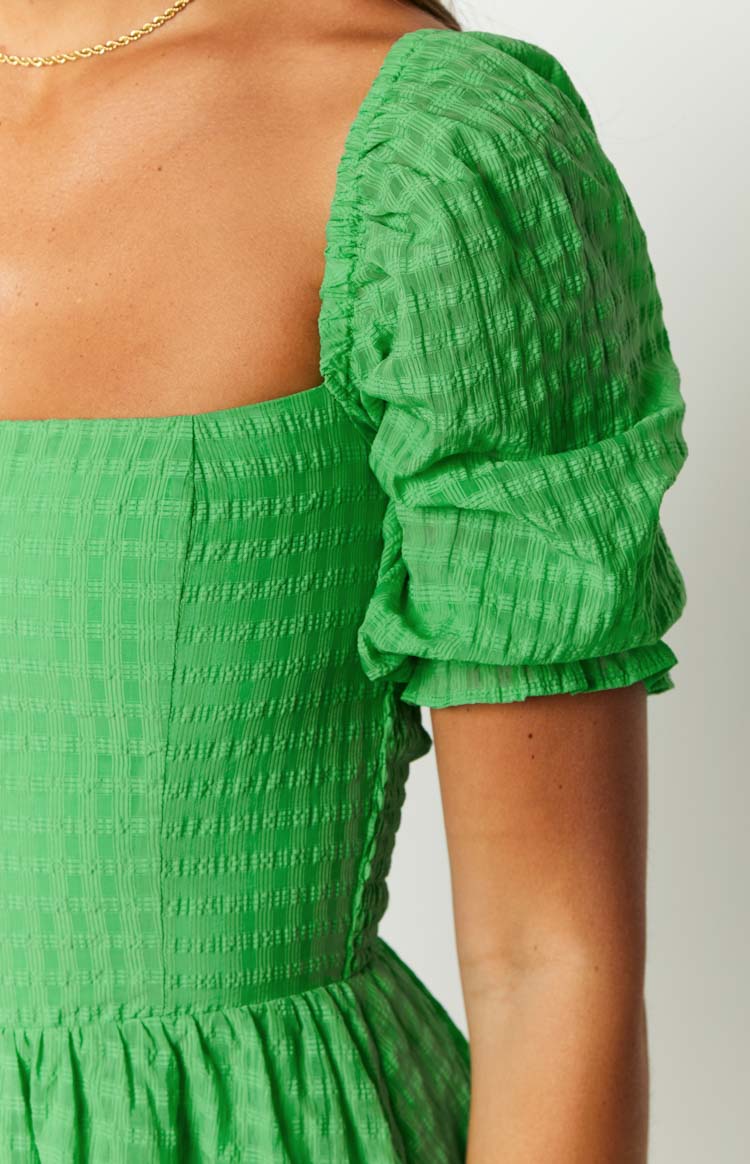 Bright green textured check playsuit with a square neckline, short puff sleeves, fitted bodice, and gathered waist