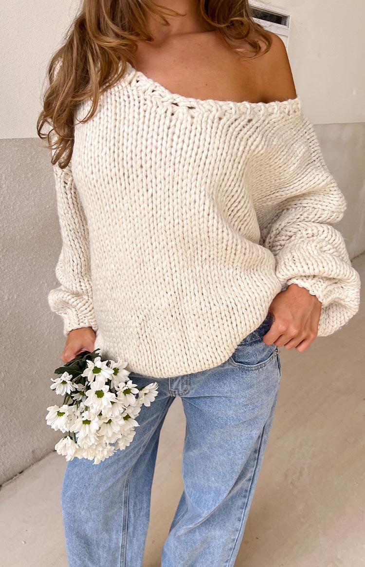 Cream chunky knit sweater with a wide off-the-shoulder neckline and voluminous balloon sleeves
