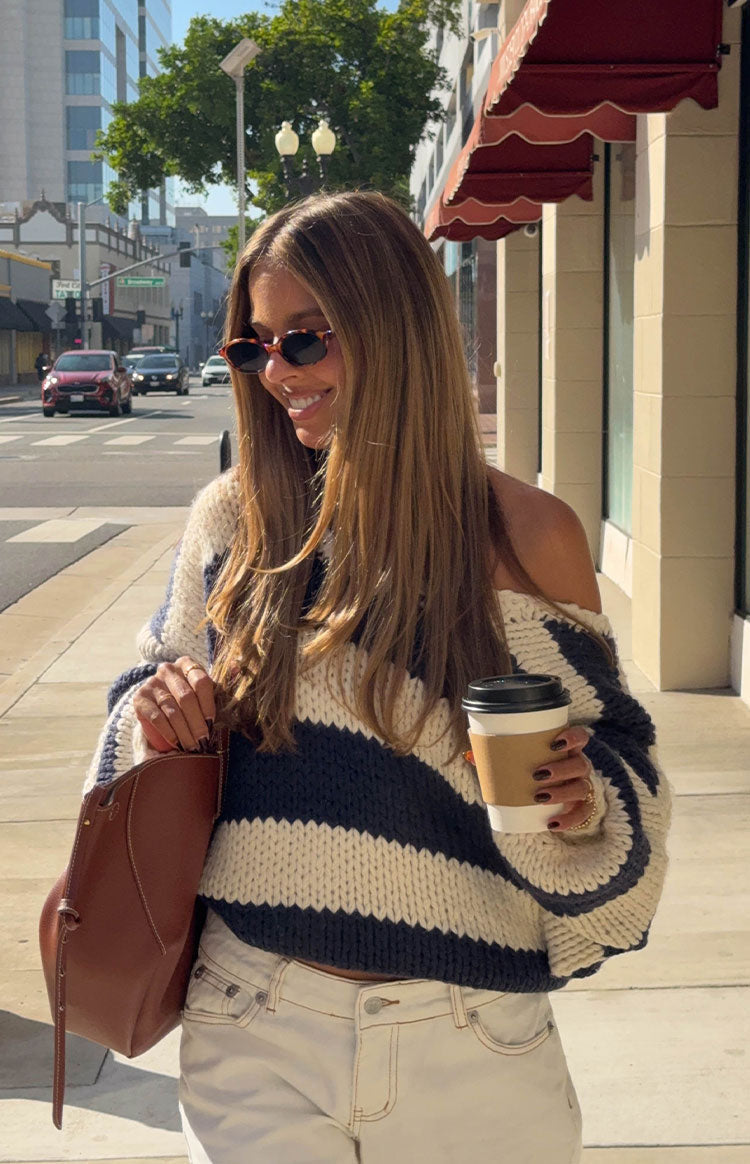 Off-the-shoulder navy and cream striped chunky knit sweater with a loose fit and cropped hem