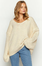 Cream chunky knit sweater with a wide V-neckline and oversized fit, showing the voluminous long sleeves