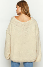 Rear view of a cream chunky knit sweater with a wide scoop back neckline and oversized fit