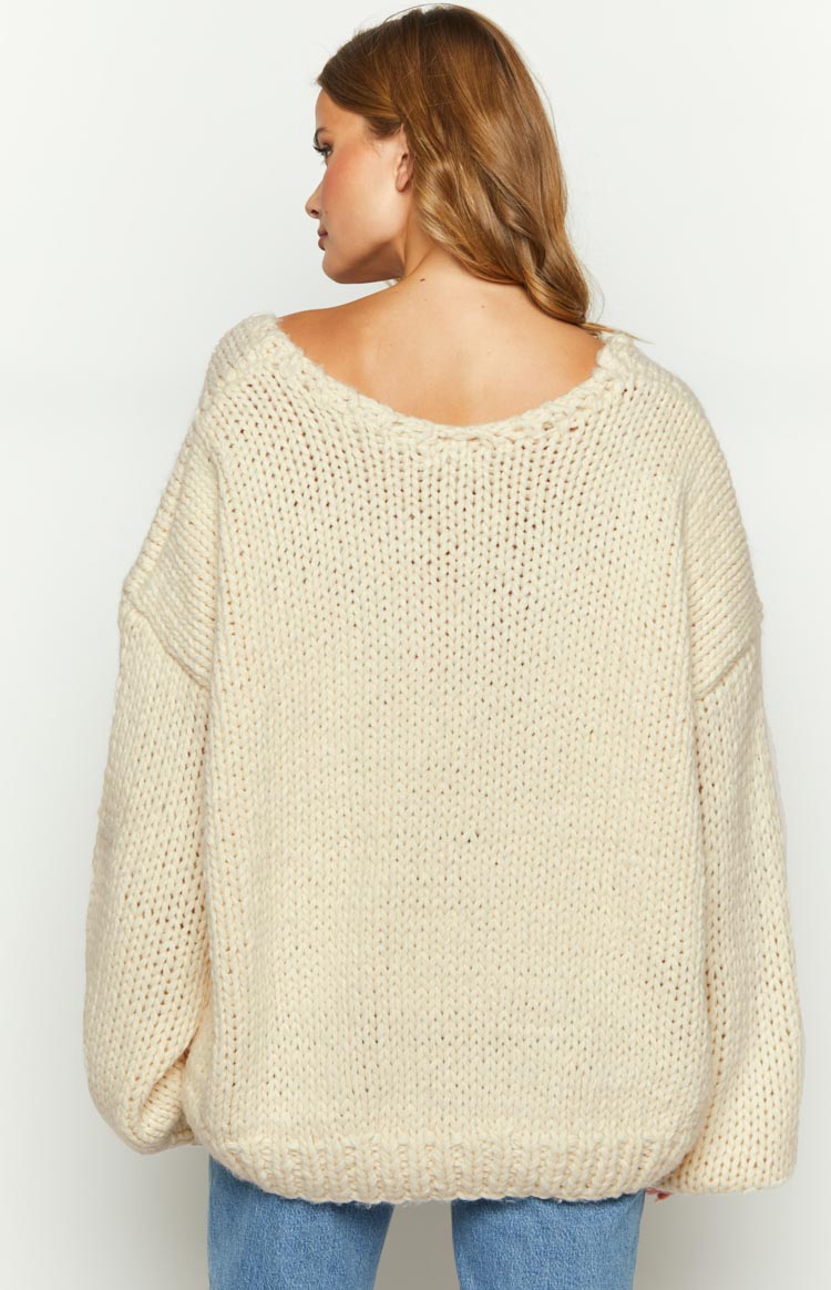 Rear view of a cream chunky knit sweater with a wide scoop back neckline and oversized fit