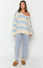 Rear and side view of a light blue and cream striped chunky knit sweater with relaxed fit and long sleeves