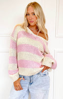 Close-up of the off-shoulder neckline and chunky knit texture of a pink and cream striped sweater