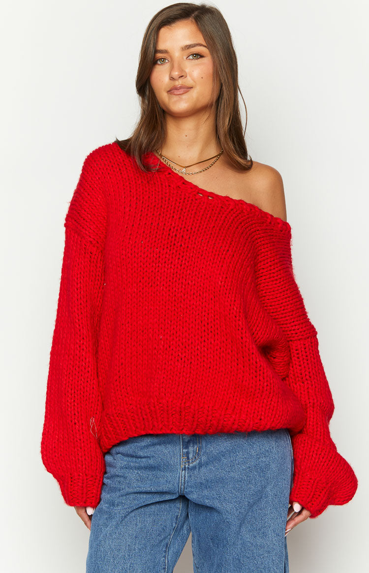 Red chunky knit sweater with a wide off-shoulder neckline, long balloon sleeves, and ribbed hem
