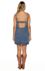 Rear view of the blue denim mini dress showing a low scoop back and a straight strap across the upper back