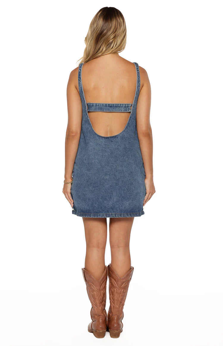 Rear view of the blue denim mini dress showing a low scoop back and a straight strap across the upper back