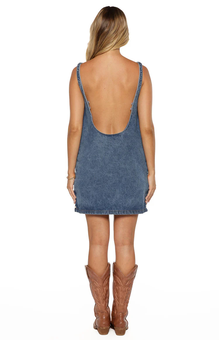 Rear view of a denim mini dress with a deep scoop back and thick straps