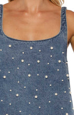 Close-up of the blue denim mini dress showing the scoop neckline and scattered white pearl details