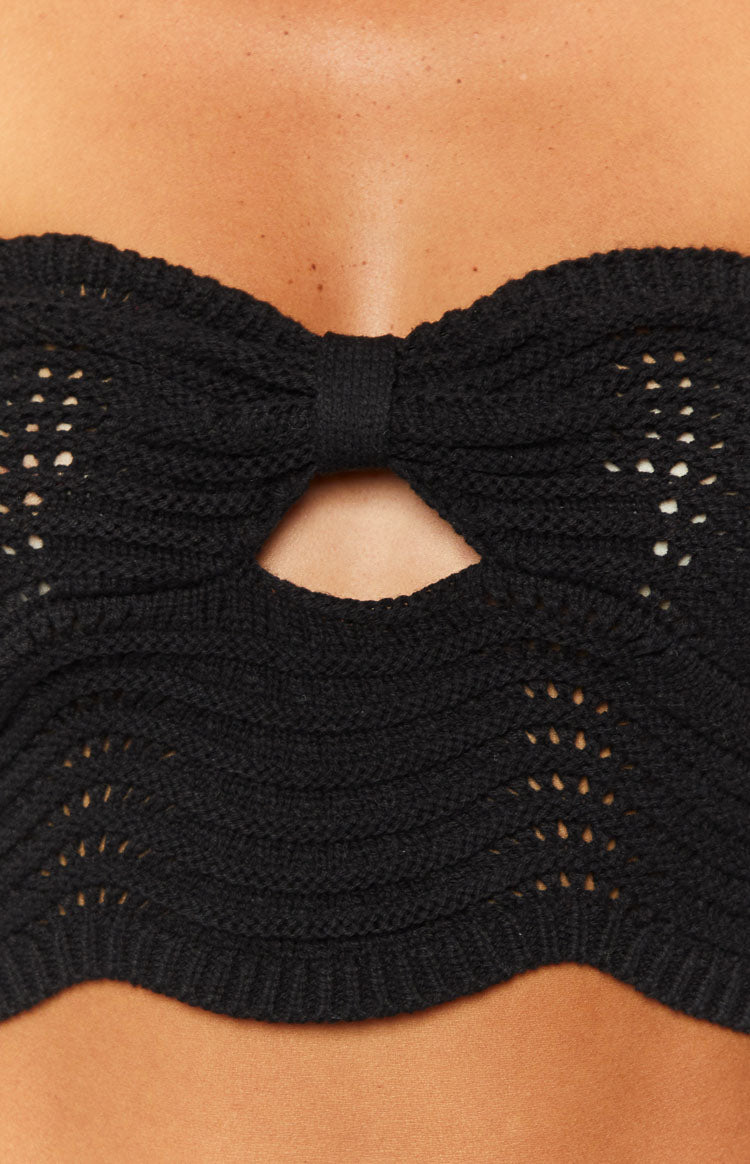 Close-up of the black knit top with a bow detail and keyhole cutout at the bust