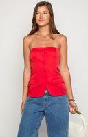 brunette model wearing a red strapless tailored top with functional buttons and faux pockets