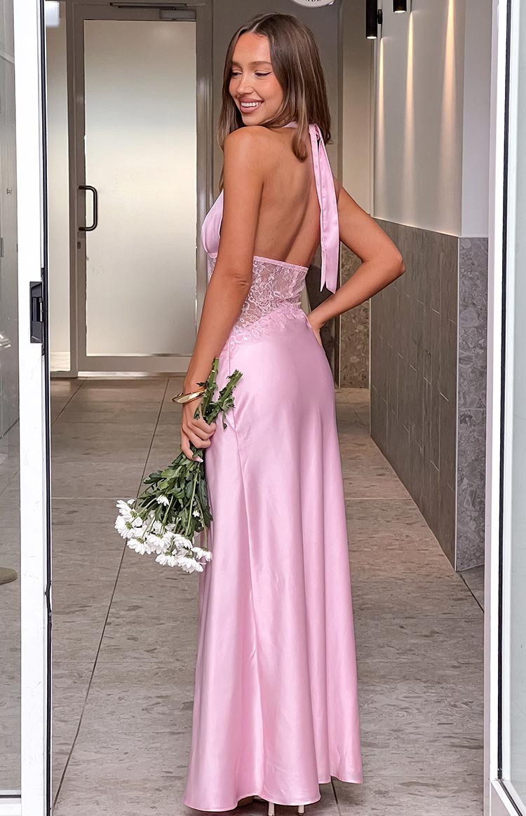 The back view of a light pink satin halter gown- showcasing a sheer lace insert at the back of the bodice and a graceful flow to the skirt. This dress is ideal for a gala or a sophisticated evening event.