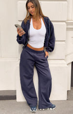 Full length view of navy barrel leg track pants with an elasticated waistband and side pockets