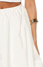Close-up of the white cotton skirt showing the elasticated waistband and gathered, voluminous fabric