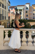 Side view of a white bubble hem skirt with a voluminous, gathered hem and relaxed fit