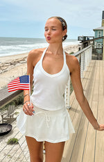 Front view of a white flowy micro skort with a gathered waist and adjustable drawstring