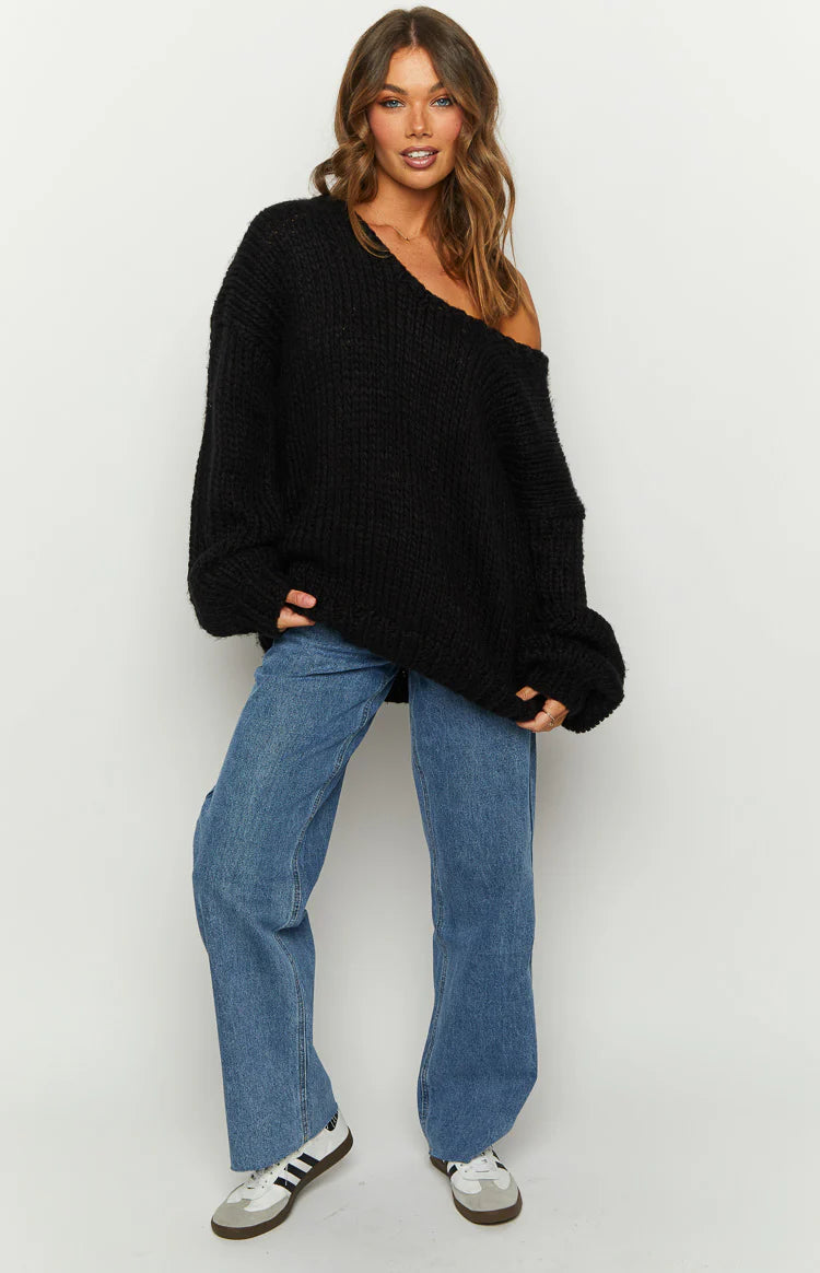 Black chunky knit sweater with an off-shoulder neckline, showing the prominent knit texture