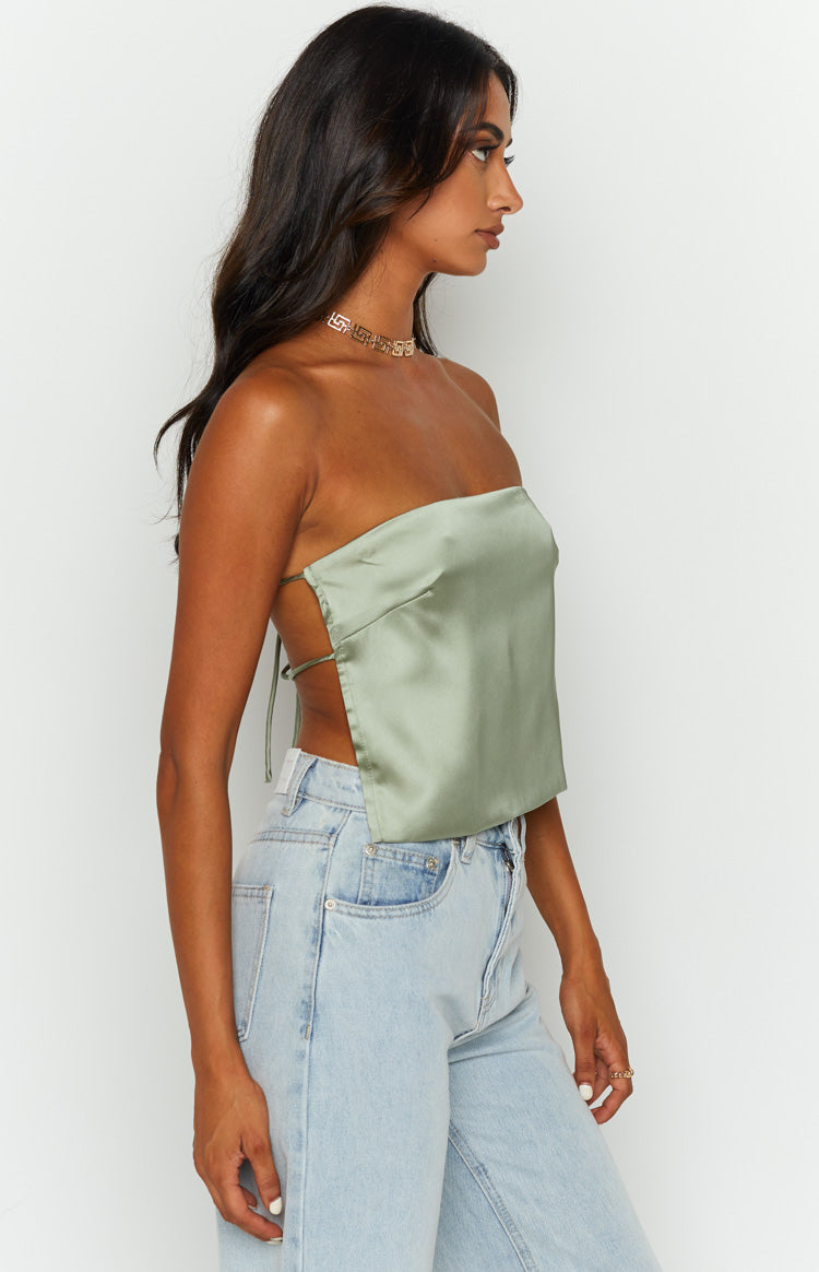 Side view of an olive satin strapless top showing the open back with thin crisscross tie straps