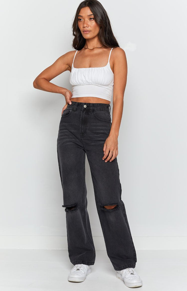 Faded black wide leg jeans with distressed ripped knees and a high-rise waist