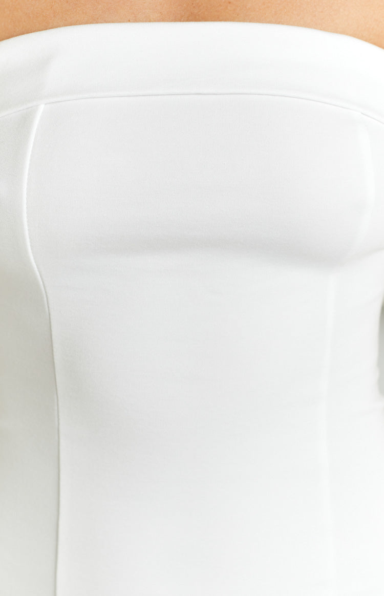 Close-up of the white strapless mini dress bodice, showing the smooth fabric and clean top edge