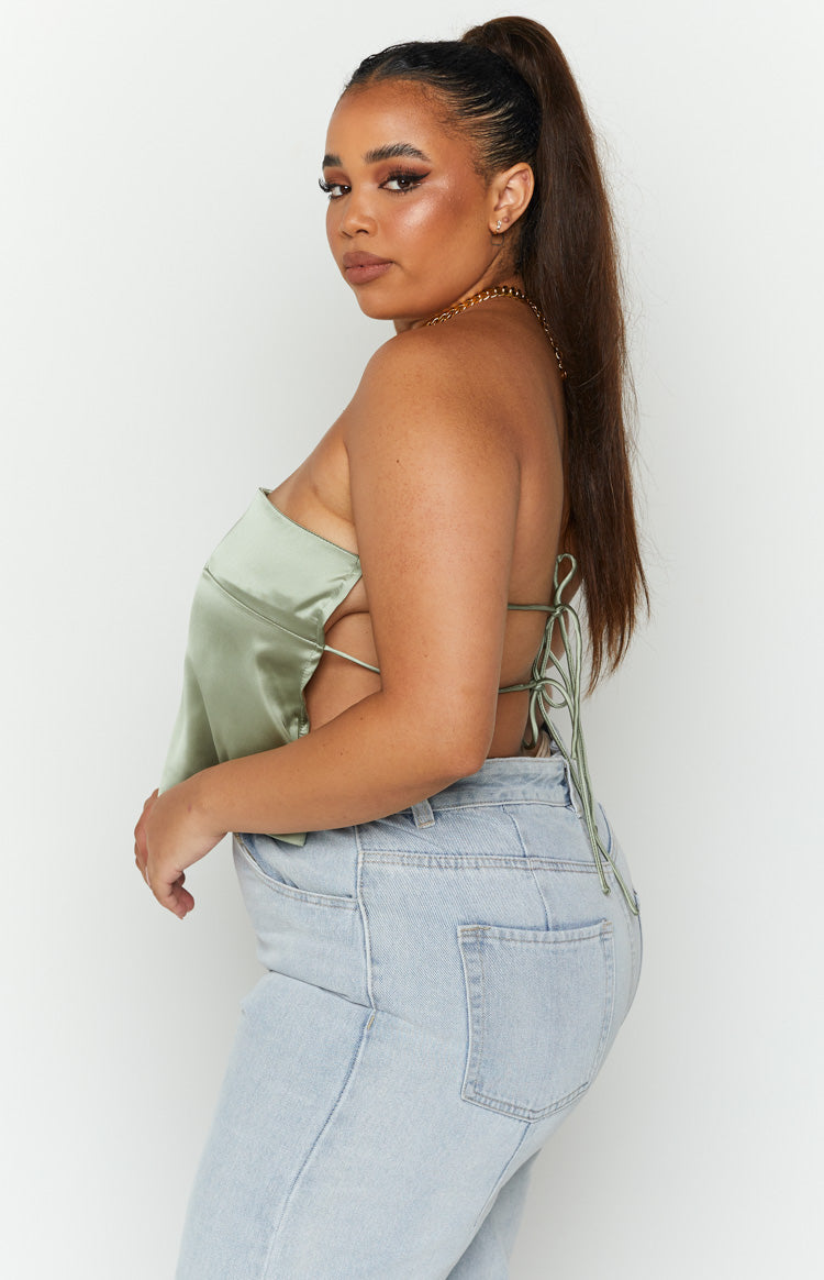 Side view of an olive satin strapless top with side cutouts and a detailed tie-back closure