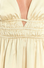 Close-up of the yellow dress showing the shirred elasticated waist and triangular cutout at the deep V-neck
