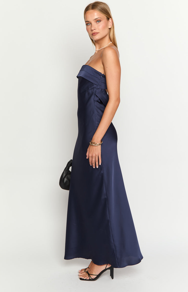 Side view of a navy satin strapless maxi dress with a folded neckline and flowing skirt